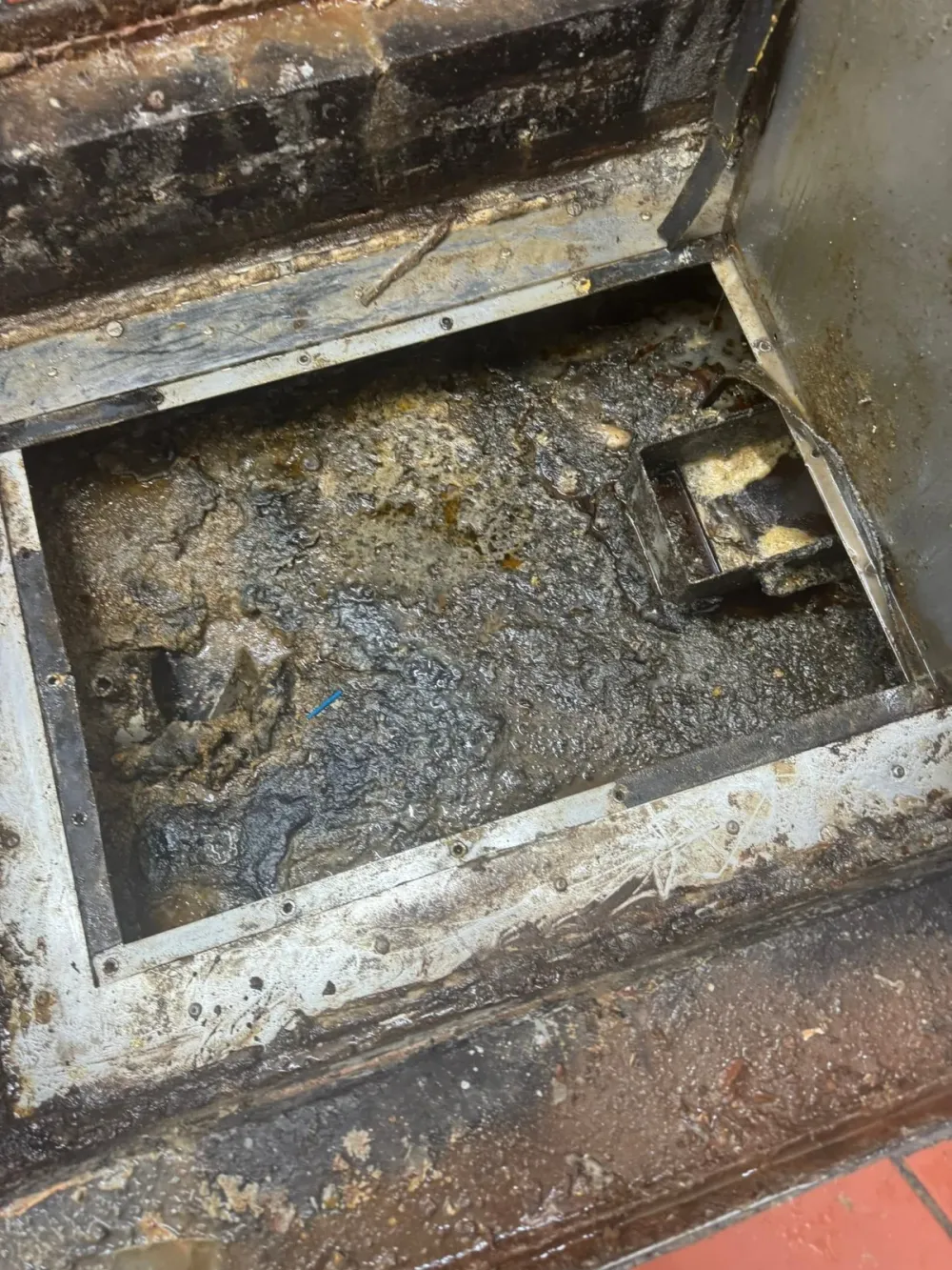 Visible grease build-up in a grease trap